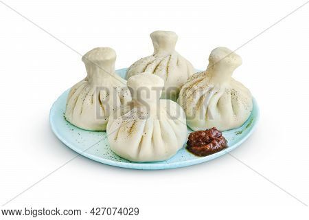Khinkali On A Saucer With Sharp Adjika Isolated On White Background