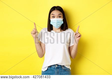 Covid-19, Pandemic And Social Distancing Concept. Young Asian Woman In White T-shirt And Medical Mas