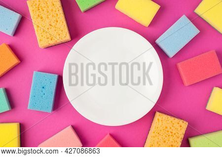 Top View Photo Of Clear Plate And Multicolor Scouring Pads On Isolated Pink Background With Blank Sp