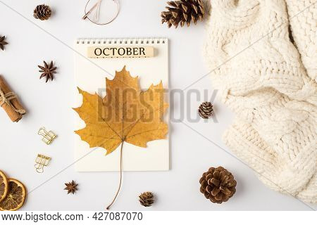 Top View Photo Of White Sweater Yellow Autumn Maple Leaf On Planner With Inscription October Pine Co