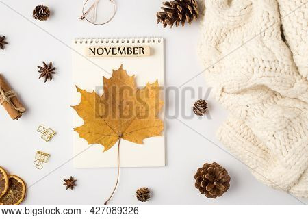 Top View Photo Of White Scarf Yellow Autumn Maple Leaf On Reminder With Inscription November Pine Co