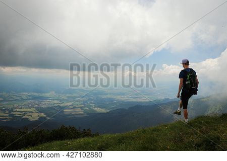 Blonde Athlete Poses On Top Of The Mala Fatra Mountain. Climbing Mount Hromova. A Hiker Walks Along 
