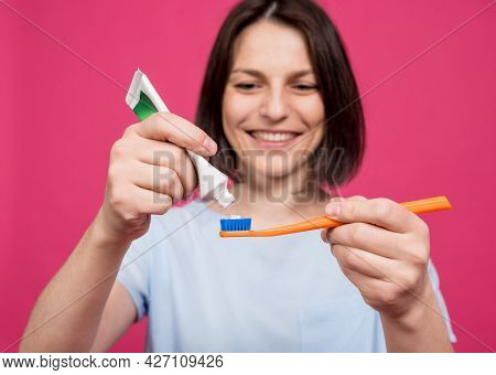 Beautiful Happy Young Woman With Toothbrush On Blank Pink Background