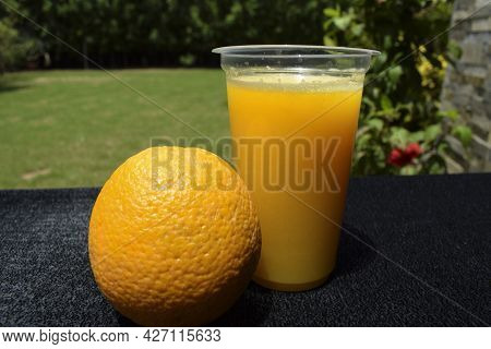 Citrus Malta Juice Served In Transparent Glass With Malta Fruit On Table. Nature Background Open Are