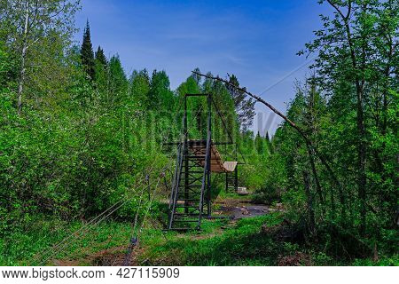 Suspension Bridge Over A Stream In A Wild Forest . Taganai National Park
