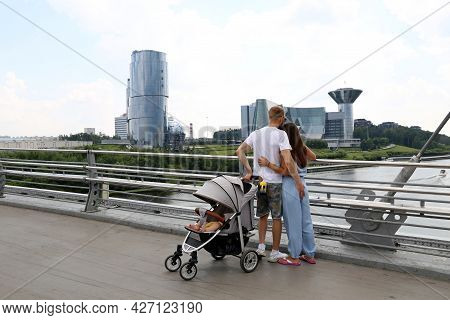Moscow, Russia - July 2021: Couple With Baby Pram Standing On The Pavshinsky Pedestrian Bridge On Ba