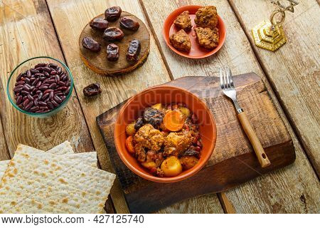 Jewish Dish Shuttle With Meat In A Clay Dish On A Wooden Table Near Matzo And Ingredients. Horizonta