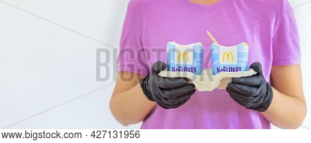 Woman In A Purple T-short Holding An Ice Cream Mcflurry In Medical Gloves. Delivery Mccafe. Fast Foo