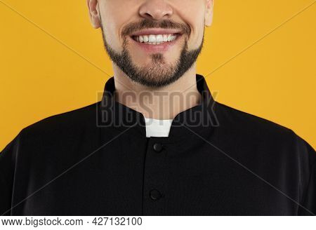 Priest Wearing Cassock With Clerical Collar On Yellow Background, Closeup