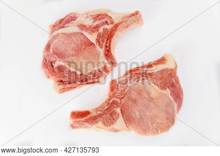 Two Pieces Of Raw Pork Chops Bone In Isoladet On White Background. Top View.
