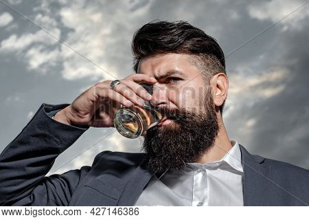 Close Up Of A Stylish Handsome Bearded Man Enjoying Brandy Or Whiskey.