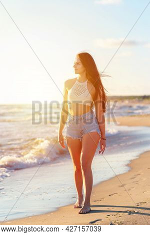 Lonely Young Woman Walking On The Beachsunset Day.beach Woman In Fashion Beachwear Relaxing Walking 
