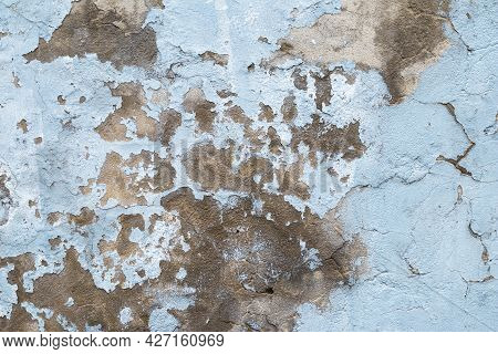 Old Concrete Wall With Peeling Paint. Close-up Of Blue Ruined Cement Wall. Abstract Grunge Stucco Te