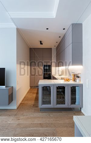 Modern Light-grey Kitchen Interior With Kooking Space And Glass Cupboard.