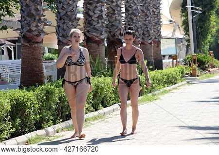 Hisaronu, Turkey​ -​ July 2021: Two Wet Girls In Bikini Walking On Palm Trees Background, Tropical V