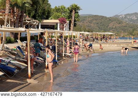 Hisaronu, Turkey​ -​ July 2021: People Sunbathing And Swimming On A Beach On Aegean Coast. Tourists 