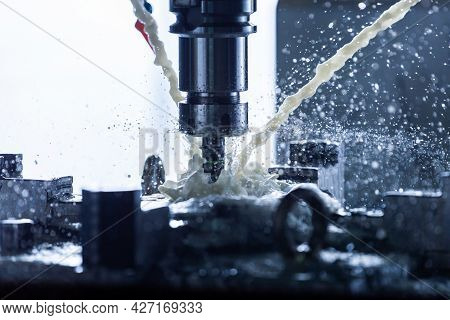 Close-up View Of Vertical Cnc Steel Milling Process With External Water Coolant Streams, Splashes An