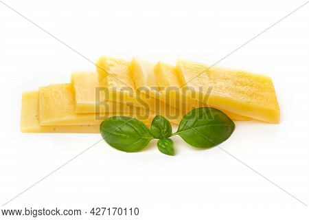 Pieces Of Semi-hard Or Hard Yellow Cheese With Holes And Basil Leaf Isolated On A White Background.