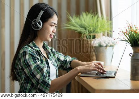 Happy Asian Woman Student Wear Heardphone Studying Online Course And Communicate By Conference Video
