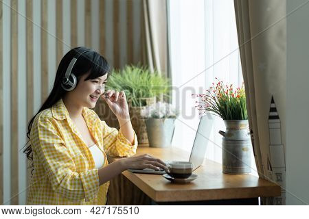Happy Asian Woman Student Wear Heardphone Studying Online Course And Communicate By Conference Video