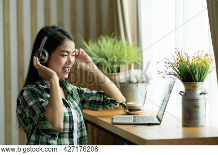 Happy Asian Woman Student Wear Heardphone Studying Online Course And Communicate By Conference Video