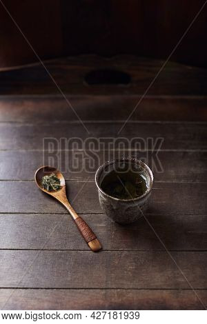 Green Tea (sencha) In A Traditional, Japanese Tea Cup And Sencha Leaves On A Wooden Tea Spoon. Dark 