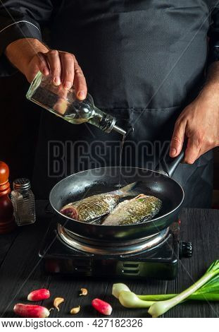 Professional Chef Prepares Fresh Fish In Pan With Oil. Preparation For Cooking Fish Food. Working En