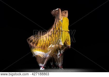 One Young Basketball Player Training With Ball Isolated On Dark Background With Stroboscope Effect. 