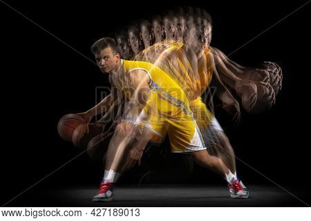 Professional Basketball Player Posing With Ball Isolated On Dark Background With Stroboscope Effect.