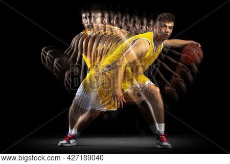 Professional Basketball Player Posing With Ball Isolated On Dark Background With Stroboscope Effect.