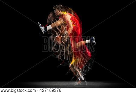 Portrait Of Young Basketball Player Training With Ball Isolated On Dark Background With Stroboscope 