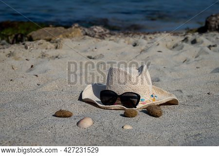 Decoration Of A Sun Hat With Sunglasses And Seashells On The Beach. Summer Decoration.