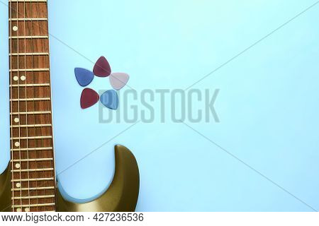 Guitar Neck Fretboard, Five Picks Plectrums And Blue Background.