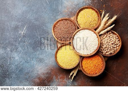 Gluten free cereals. Rice, buckwheat, corn groats, quinoa and millet in wooden bowls. Top view flat lay with copy space