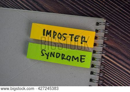 Imposter Syndrome Write On Sticky Notes Isolated On Wooden Table.