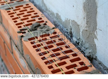 Wall Ties In Brick Masonry. A Close-up Of A Masonry Wall Tie, Mesh Wall Wire To Bond Face Brickwork,