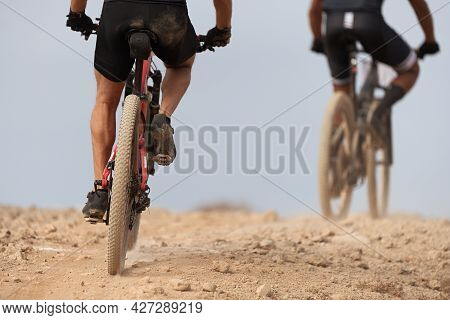 Mountain Biker Riding On Bike Singletrack Trail, Back View Of Mountain Biker. Mountain Bike Race