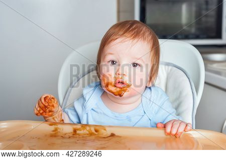 Baby In Highchair Covered In Fruit, Vegetable Puree Close-up. Complementary Feeding Tredhead Oddler 