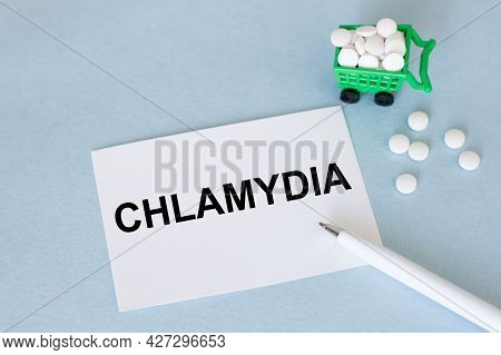 Card With The Text Chlamydia On A Blue Background Next To Scattered Pills