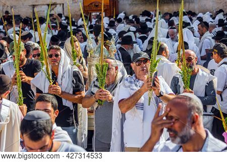 JERUSALEM, ISRAEL - SEPTEMBER 26, 2018: The Jews of ritual clothes - tallit hold four ritual plants. The area in front of Western Wall of Temple filled with people. Blessing of the Kohanim, 