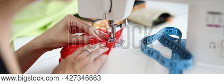 Woman Sew On Red Fabric On A Sewing Machine