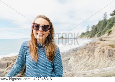 Brunette Woman With Long Hair Smiles And Poses At Kalaloch Beach In Olympic National Park