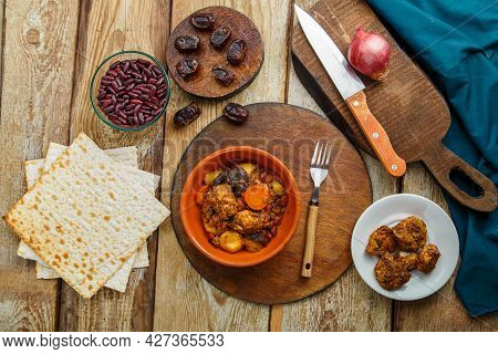 Jewish Dish Chelnt With Meat In A Plate On A Wooden Table On A Stand Next To A Knife And Ingredients