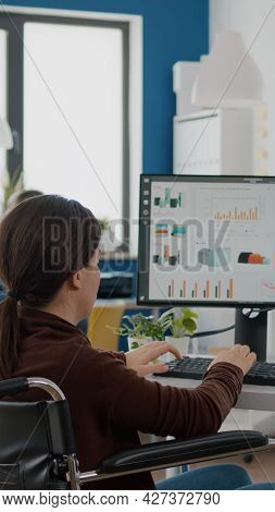 Paralysed Financial Expert Sitting In Wheelchair Analysing Economy Statistics Of Company In Business