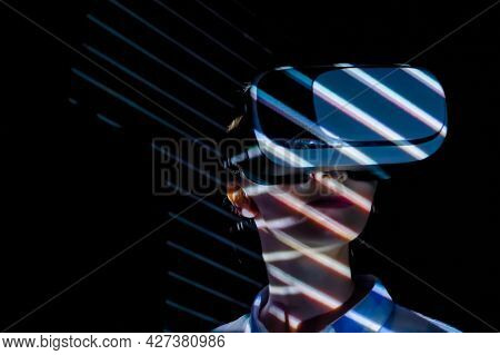 Woman Using Virtual Reality Headset And Looking Around At Interactive Technology Exhibition With Col