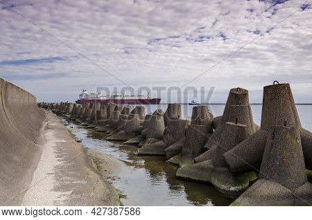 Dolos And Lng Tanker - Ship Against Background Of Concrete Protection Of The Seaport And Sea Coast