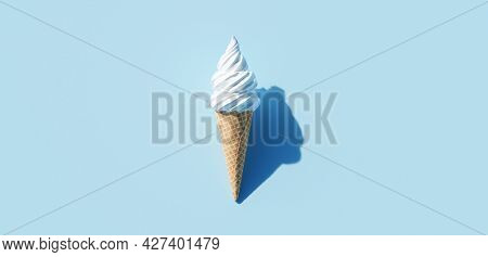 Soft serve ice cream in a cone on blue background
