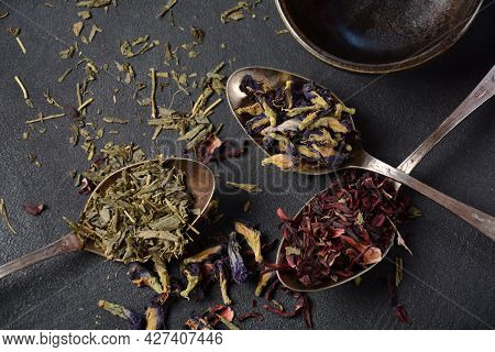 Various Kinds Of Dry Tea Bancha Green, Hibiscus, Butterfly Pea Flower Tea In Spoons On The Table
