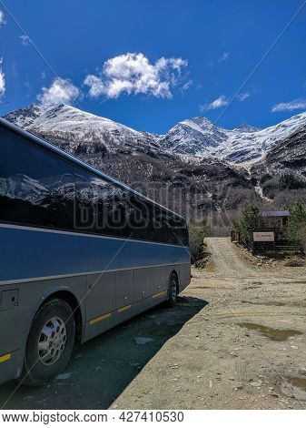 Mount Cheget, Russia - May 10, 2021: View Of Mount Cheget With Snow-capped Peaks Against A Blue Sky.