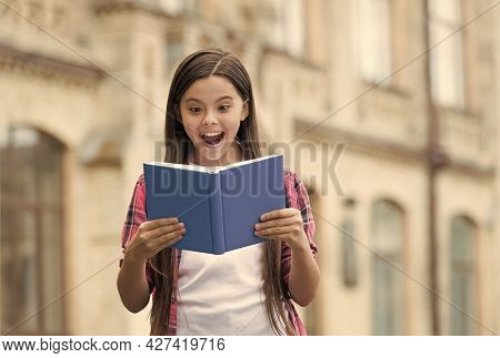 Discover Something New. Happy Child Read Book Outdoors. Excited Bookworm With Open Mouth. School Lib